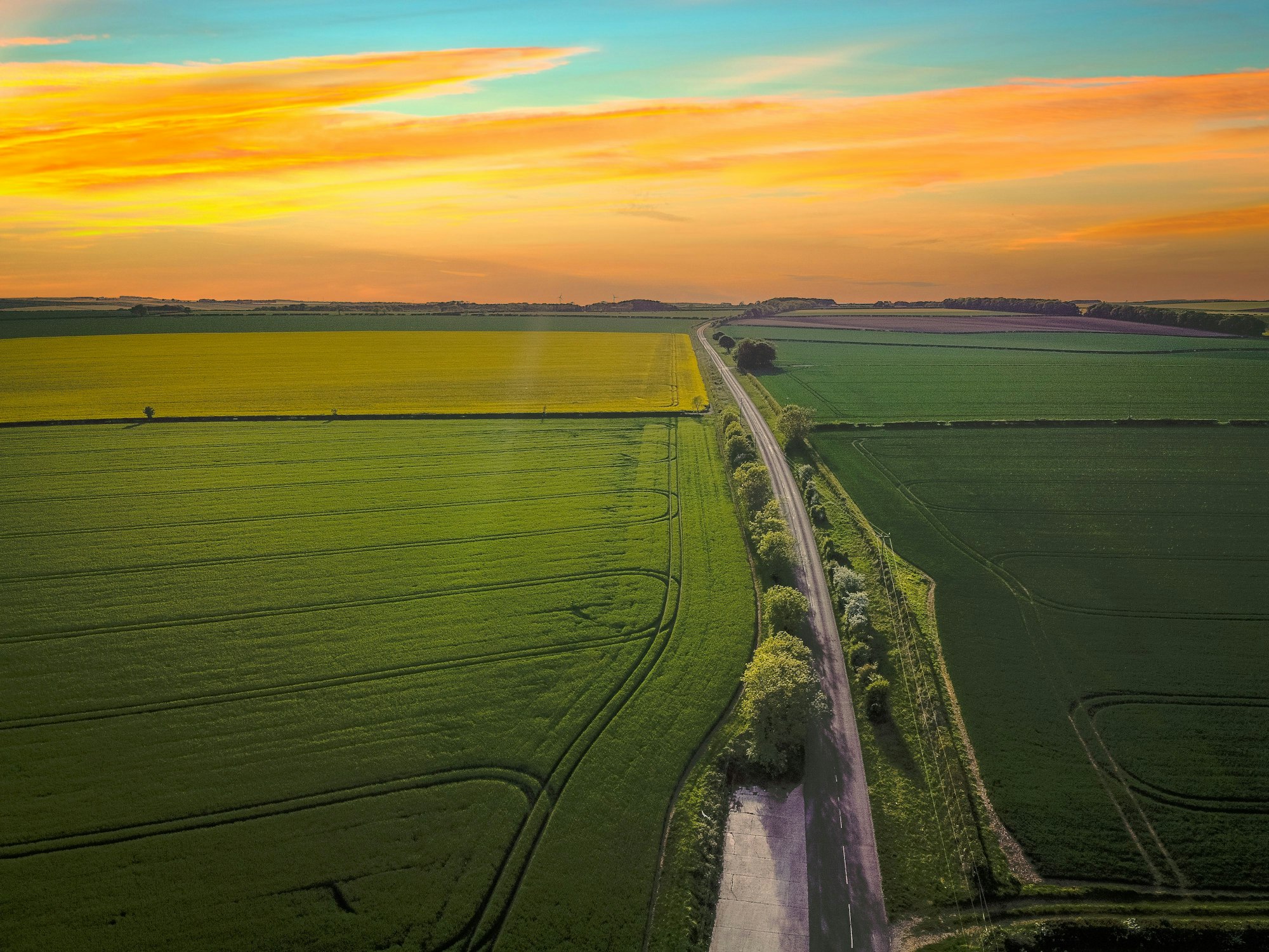 Aerial view of a stunning sunset at cultivated land in the countryside on a summer evening