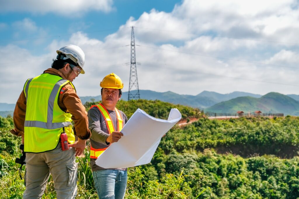 Two engineer man discuss together for the construction in far away land that cover with the forest.